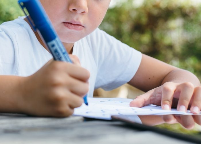 Crop child studying in garden